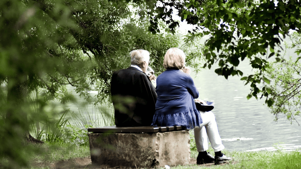 Couple sitting by river discussing estate planning